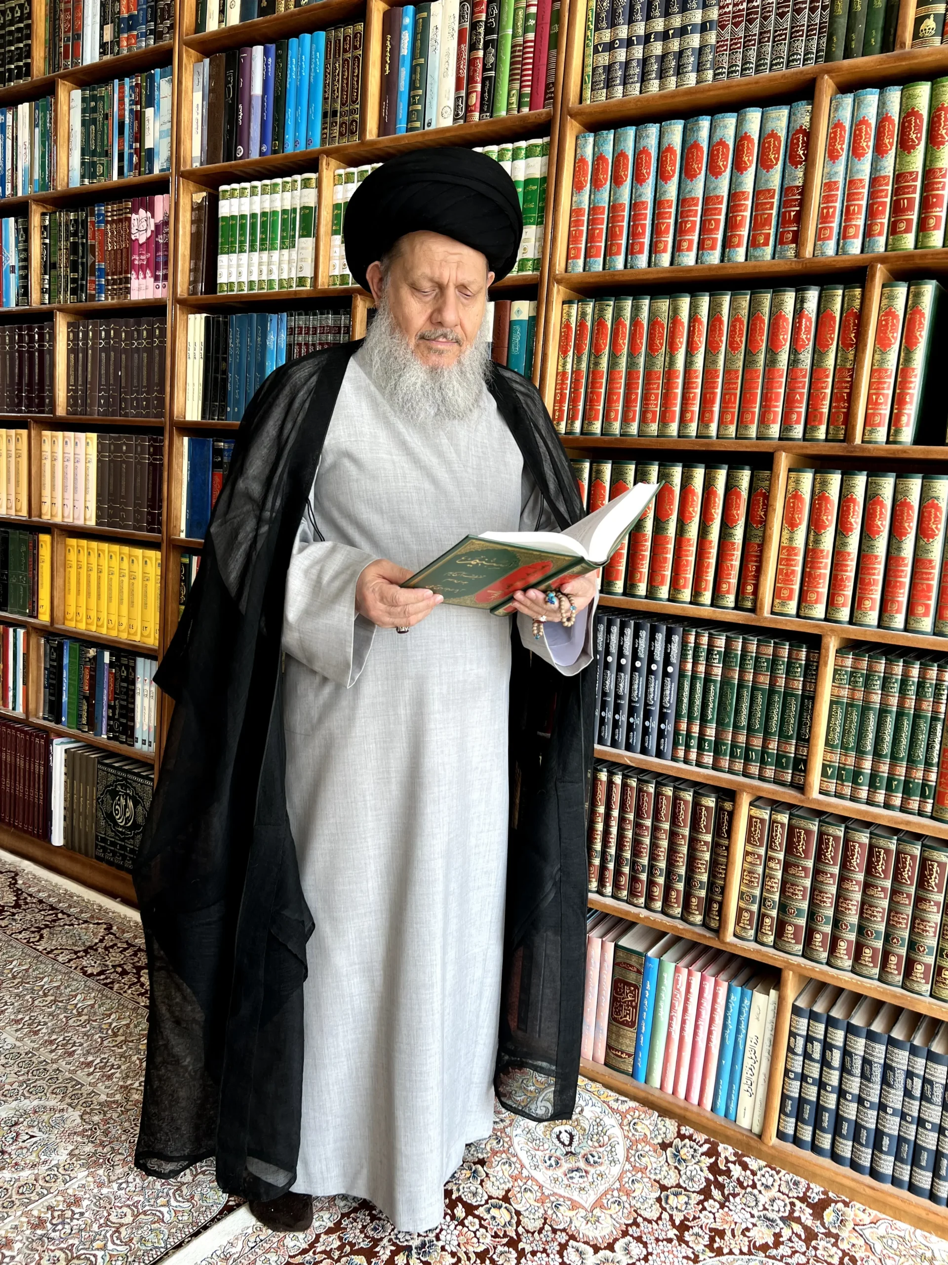 سماحة السيد كمال الحيدري يقرأ كتاباً في مكتبته